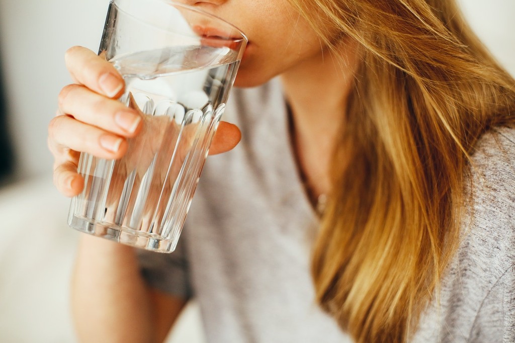 Person drinking a glass of water